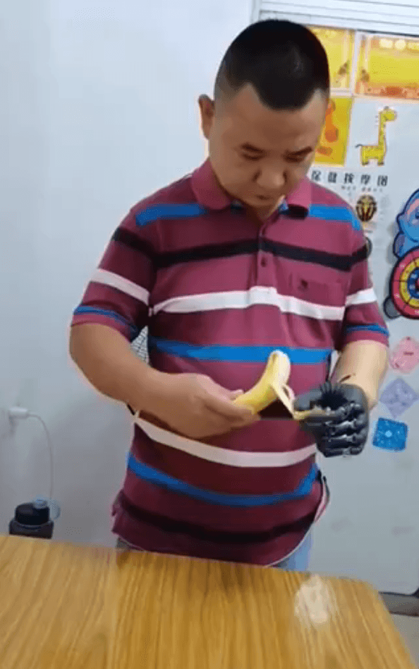 吴先生正使用BrainCo智能仿生手，慈爱地为儿子削水果